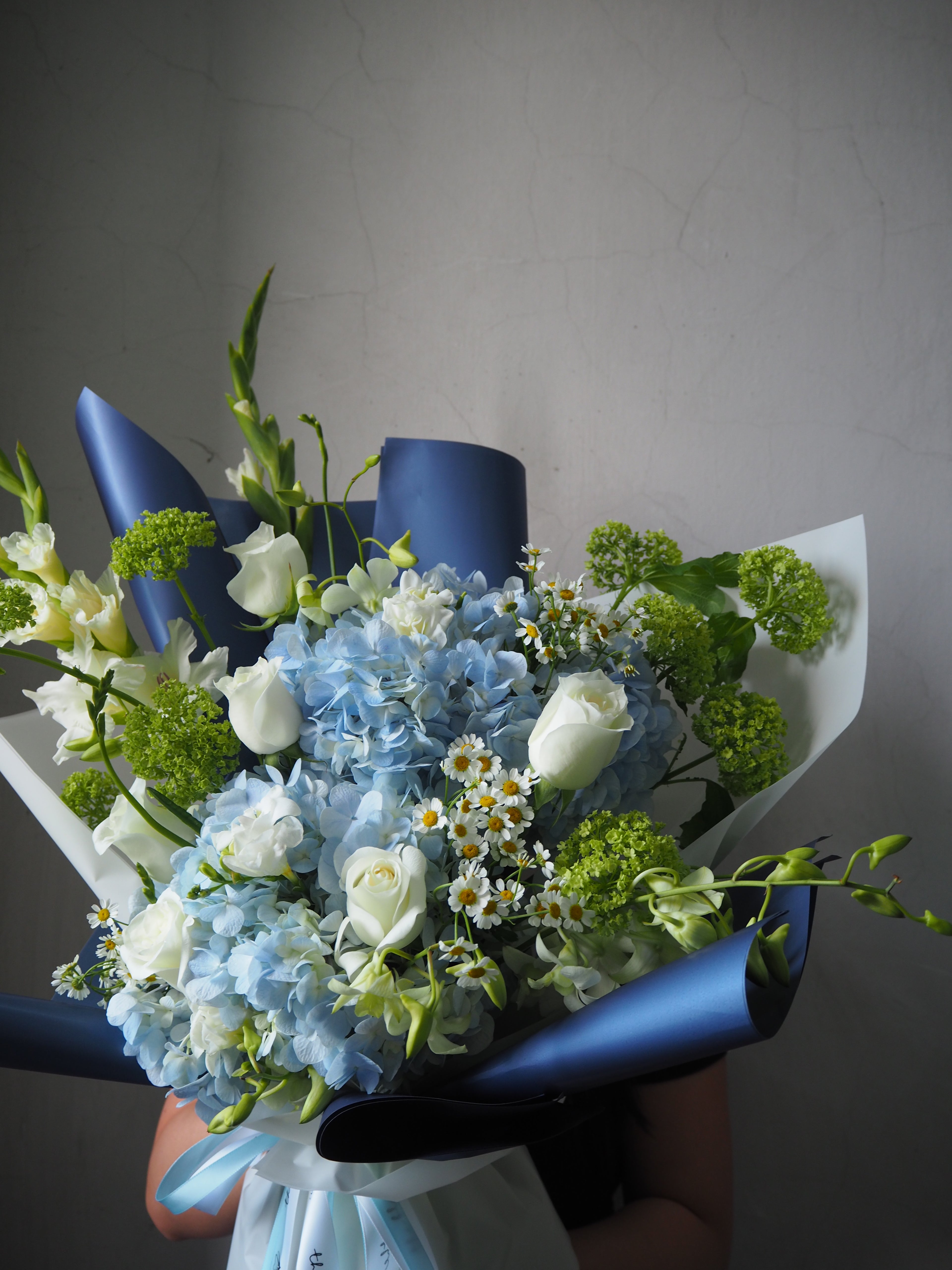 Bouquet of flowers with blue ribbons on a plain background