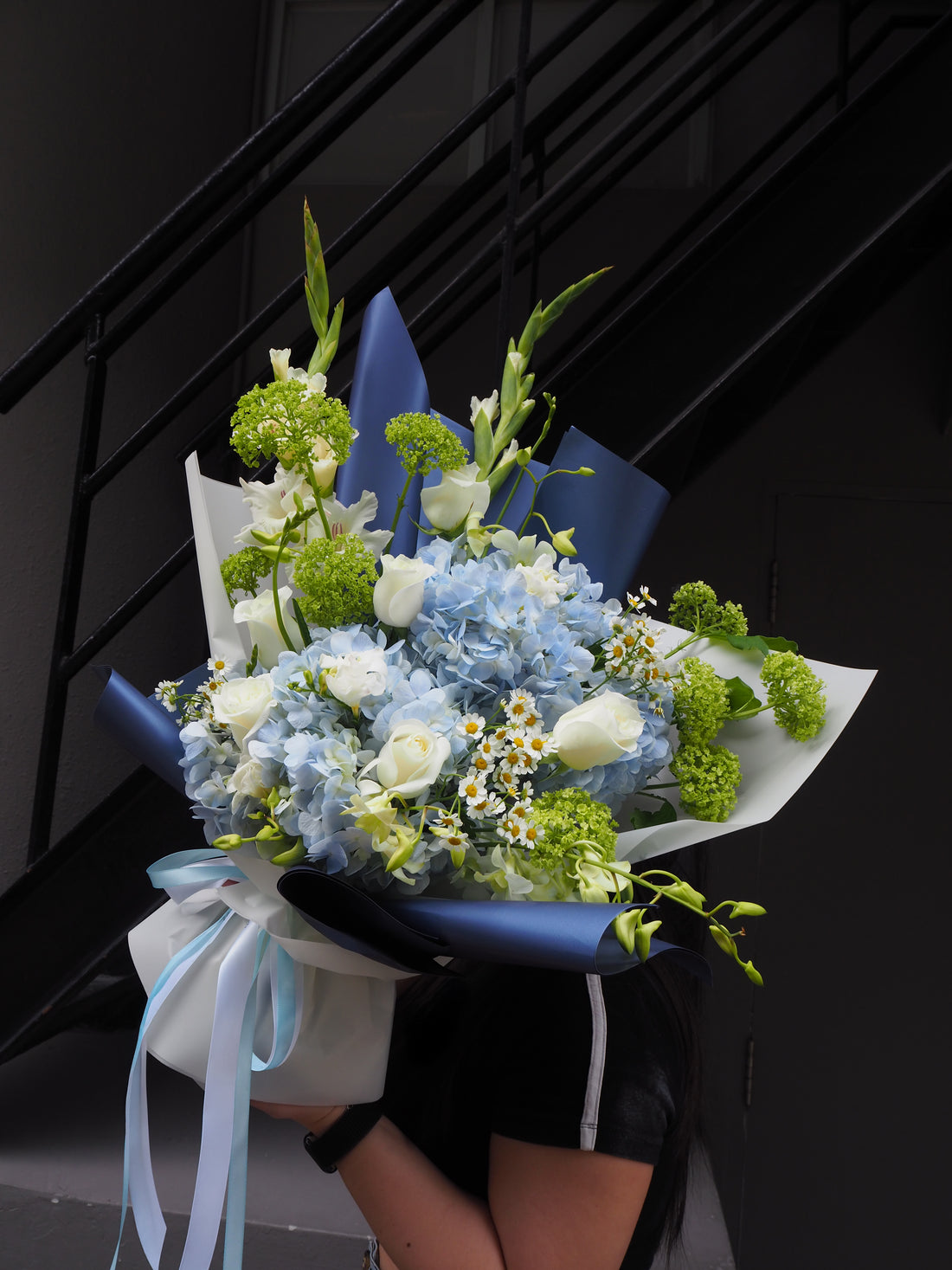 Bouquet of flowers held by a person against a black background