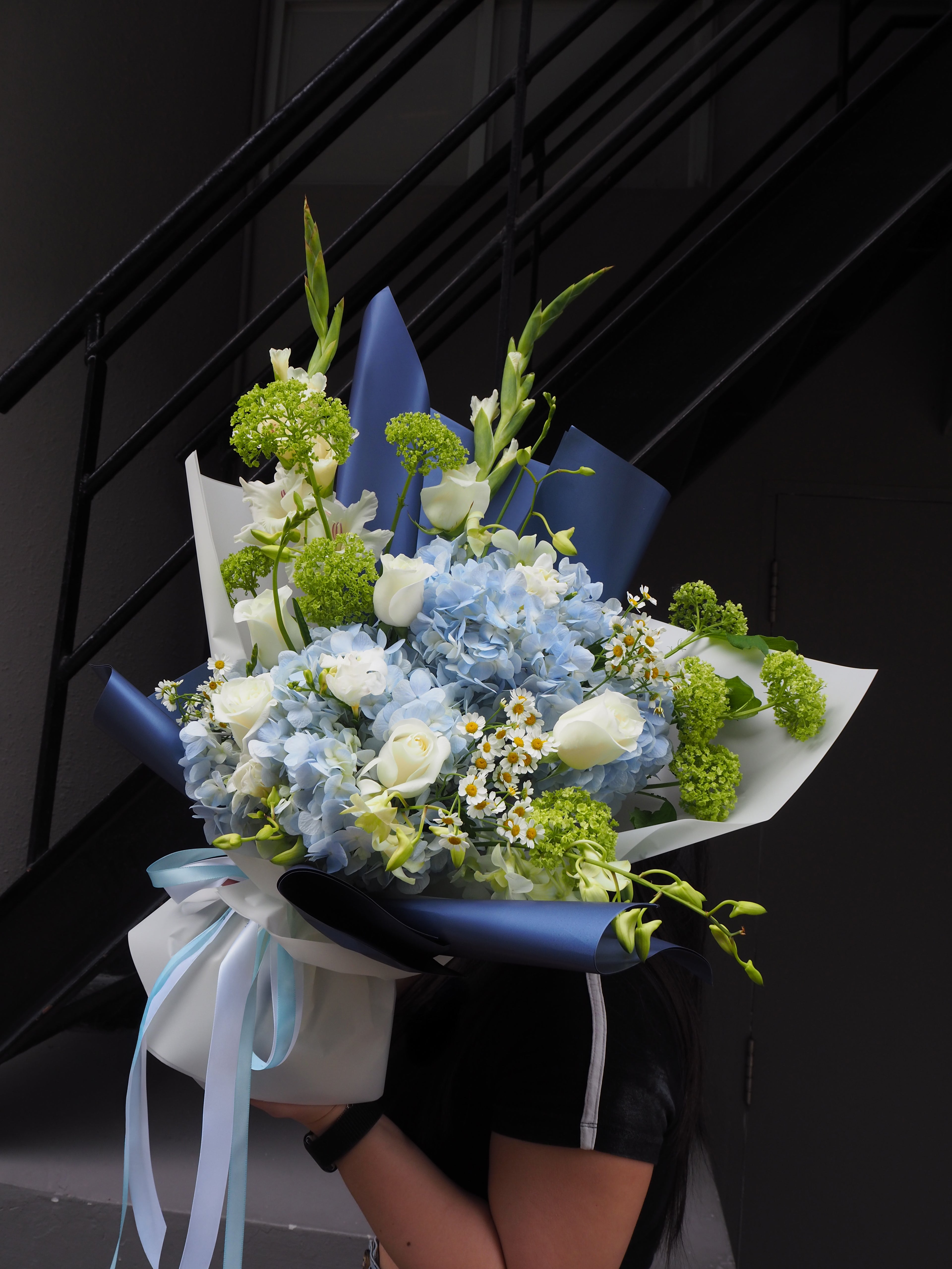 Bouquet of flowers held by a person against a black background