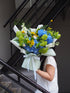 Person holding a bouquet of flowers on a staircase