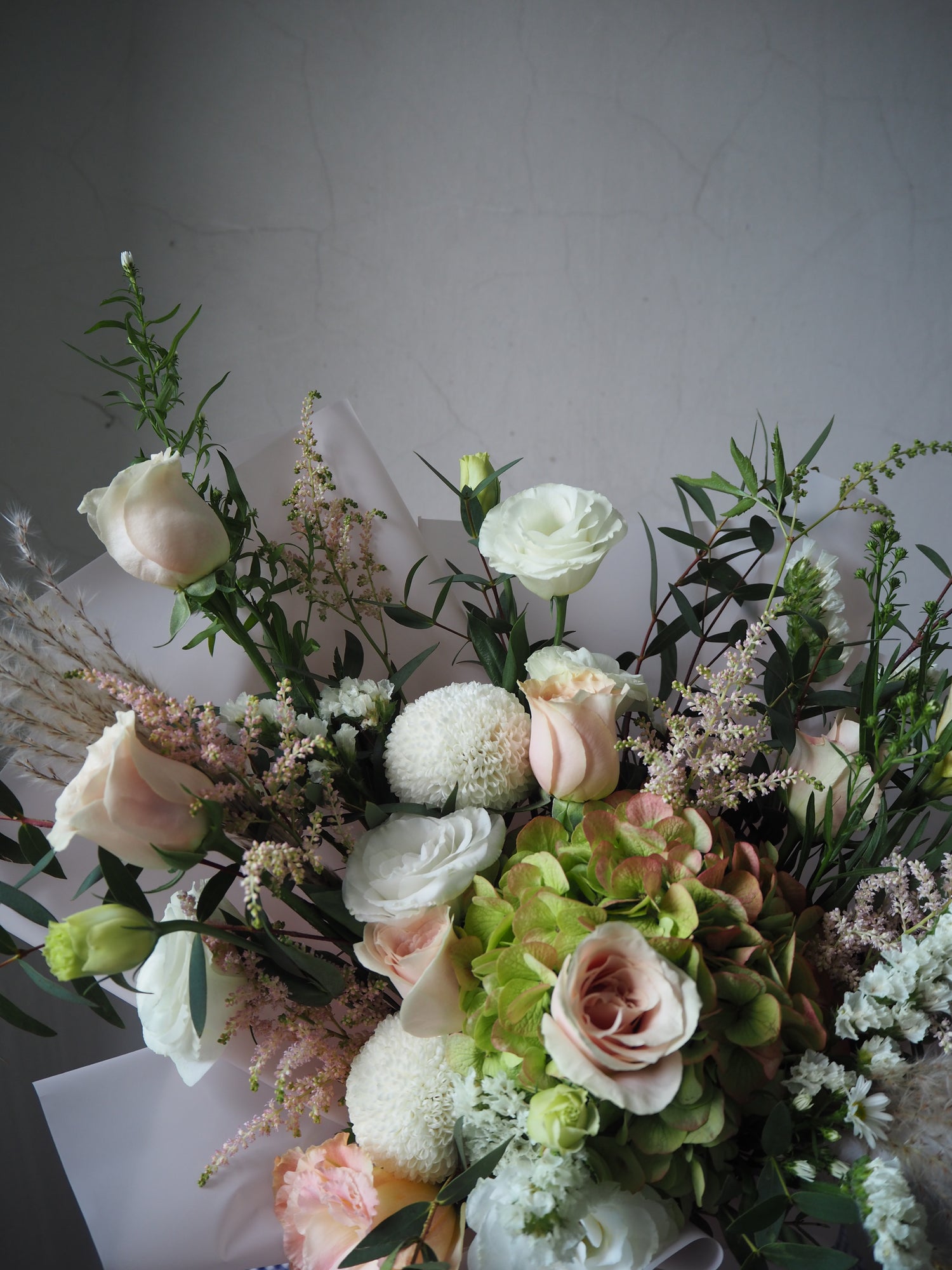 Bouquet of flowers with greenery on a light gray background