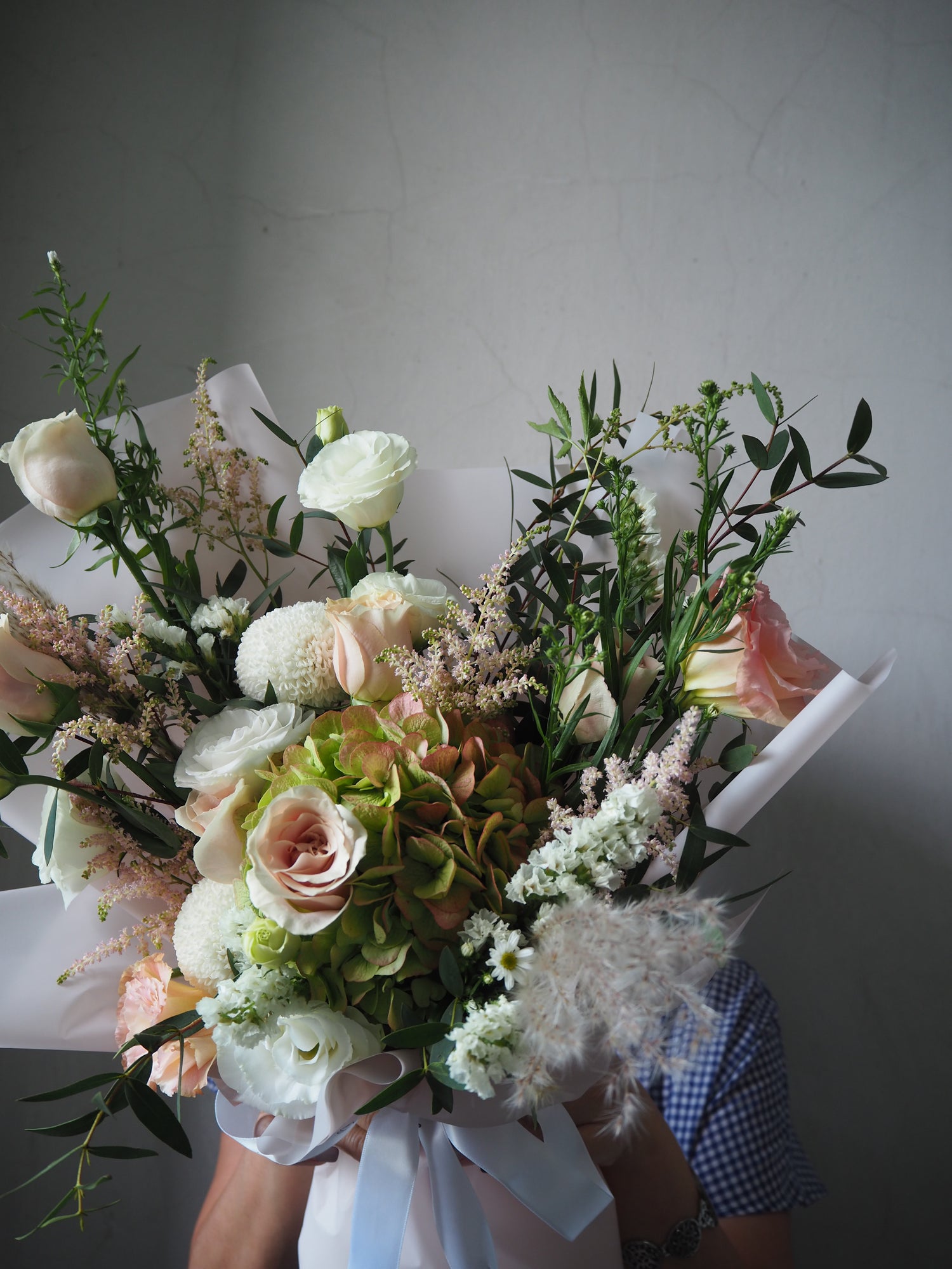 Bouquet of flowers with a person wearing a checkered shirt in the background