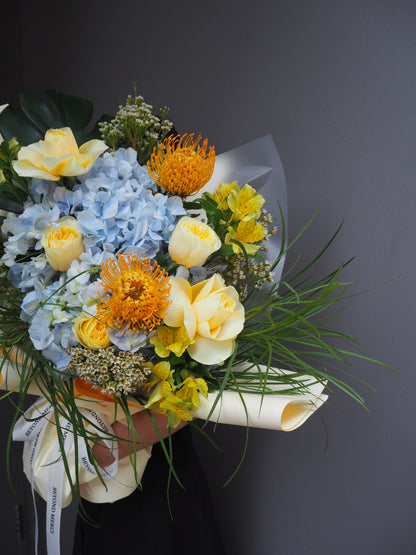 Fresh bouquet of flowers with yellow and blue flowers on a dark background