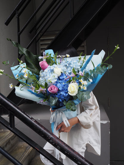 Unique luxury fresh flower bouquet with blue hydrangeas and purple roses