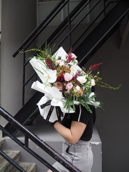 Person holding a large bouquet of flowers on a staircase