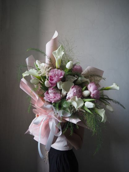 Luxury bouquet of fresh pink peonies and white calla lily wrapper with pink wrapper from Beyond Merci premium florist